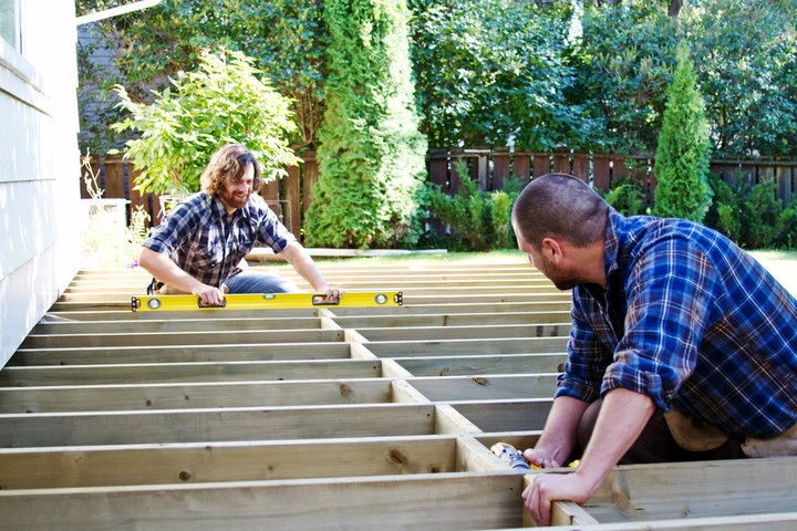 Deck builders reinforcing the structural framework of a residential custom deck in Houston